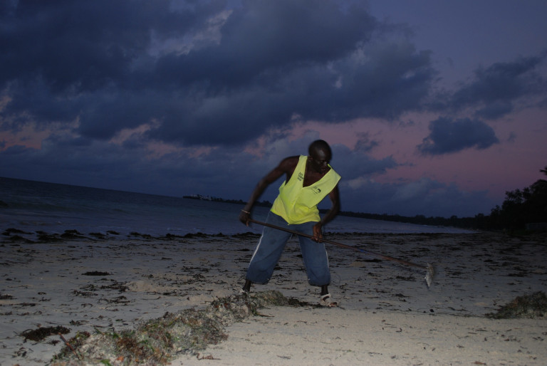 Man cleaning beach for tourists